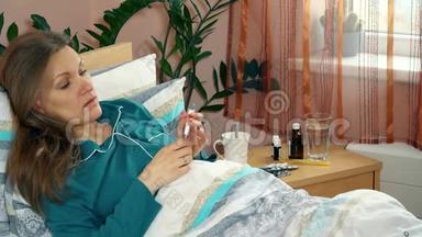 病妇躺在床上用电子体温计测量体温